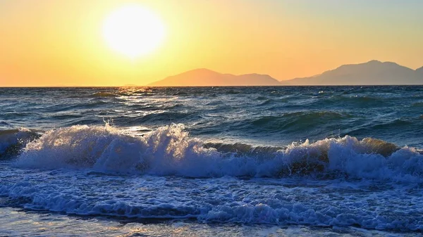 Hermoso atardecer con mar y olas. Fondo colorido natural. Concepto para vacaciones de verano y de mar. Grecia - isla de Kos . — Foto de Stock