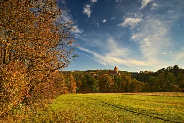 Beautiful autumn landscape with old castle Veveri at sunset and beautiful blue sky with clouds. Colorful nature background on autumn season. Brno - Czech Republic. — Stock Photo, Image