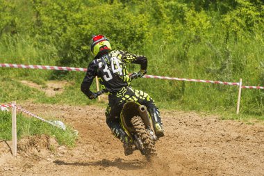 Lviv, Ukrayna - 20 Mayıs 2018: Motokros pistinde Açık Lviv Kupası. Bilinmeyen motosiklet yarışçısı, şampiyonluk maçında motokros pistinin üstesinden geldi..