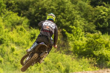 Lviv, Ukrayna - 20 Mayıs 2018: Motokros pistinde Açık Lviv Kupası. Bilinmeyen motosiklet yarışçısı, şampiyonluk maçında motokros pistinin üstesinden geldi..