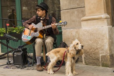Bir sokak müzisyeni ve bir köpek melodi çalıyor.