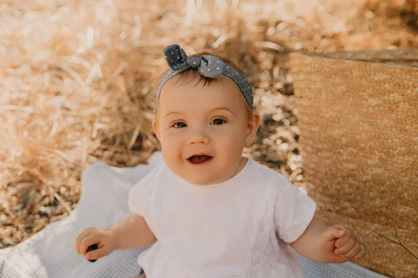 Ekose üzerinde oturan güzel bir kız bebek. Çocuk dışarıda. Bebek yazın piknikte. Güzel küçük kız.. — Stok fotoğraf