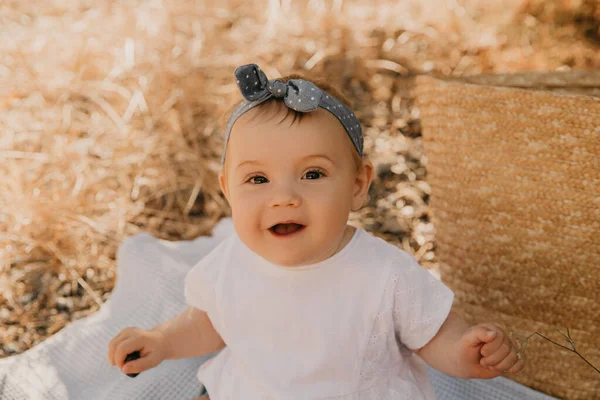 Hermosa niña sentada en el cuadros. Niño al aire libre. Bebé en el picnic en verano. Linda niña. . — Foto de Stock