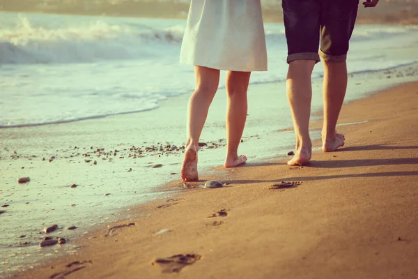 Noiva e noivo andando na praia descalço pisando na água — Fotografia de Stock