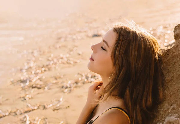 Chica en traje de baño disfrutando y caminando en la playa, en verano, en la puesta de sol. Retrato de una joven feliz sonriendo al mar . —  Fotos de Stock