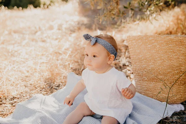 Hermosa niña sentada en el cuadros. Niño al aire libre. Bebé en el picnic en verano. Linda niña. . — Foto de Stock