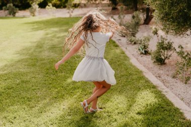 Yazın yeşil çimlerde dönen bir kız