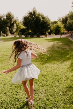 Yazın yeşil çimlerde dönen bir kız
