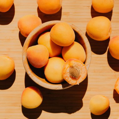  Ahşap bir arka planda ahşap bir tabakta kayısılar