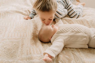 Erkek kardeş kız kardeşini öpüyor.