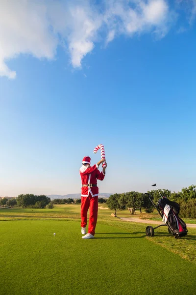 Golf sahasında şeker kamışlı Noel Baba.