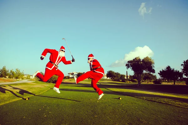 Golf sahasında zıplayan iki Noel Baba..