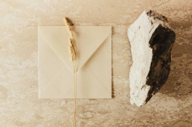 El işi zarf, boş tebrik kartı, taş. Düz yatış, üst görünüm. 