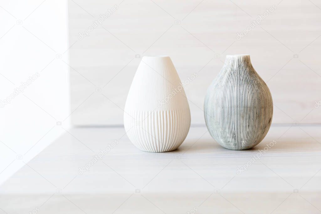 Two clay vases on a white wooden shelf.