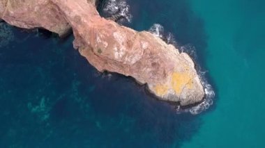 Dik sahildeki kuş bakışı manzara kristal berrak turkuaz deniz, kayalar ve uçurumlarda dalgalar. Mavi okyanus dalgaları. Diana 'nın mağarası Kırım' a kuş bakışı bakıyor..