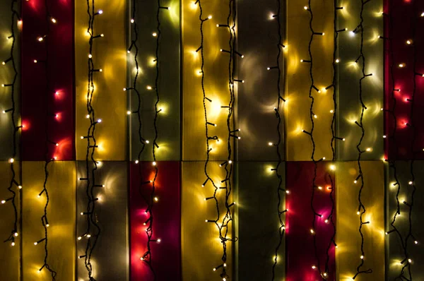 Świąteczne Girlandy Świecą Ciemności Tle Kolorowych Ścian — Zdjęcie stockowe