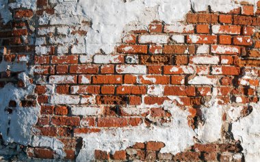 Duvarında eski boyalar olan eski bir tuğla. Kırmızı tuğla.