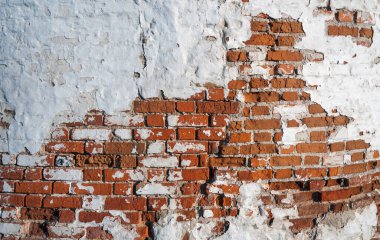 Duvarında eski boyalar olan eski bir tuğla. Kırmızı tuğla.
