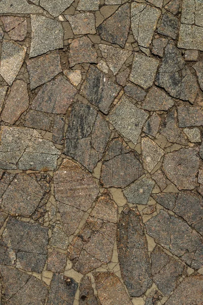 多くの亀裂と異なる色の混沌とした花崗岩の石の歩道の質感 — ストック写真