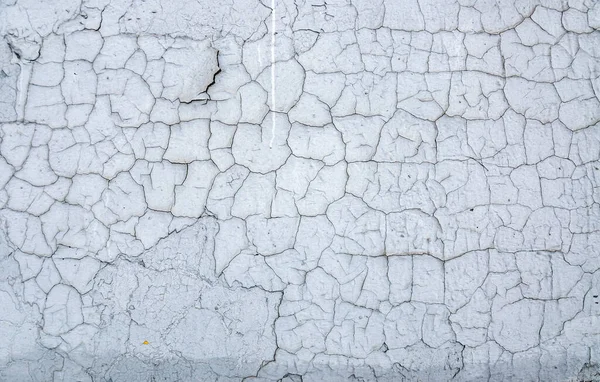 Texture cracked white paint on a stone wall.