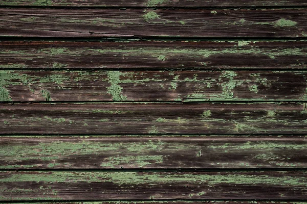 Texture of an old wooden wall of boards with peeling green paint