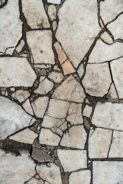 A lot of cracks on the stone sidewalk texture