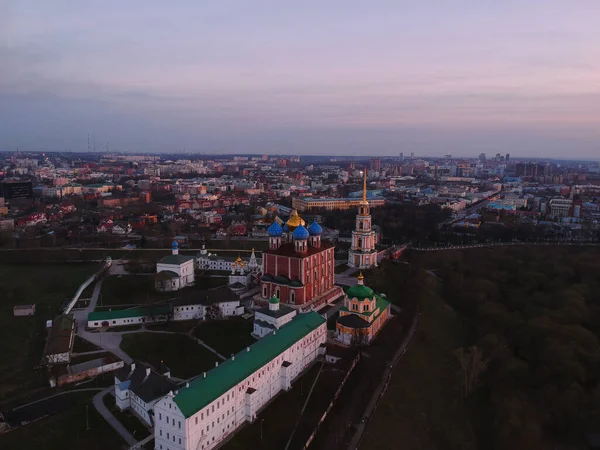Gün batımında kuş bakışı görüntüden Ryazan Kremlin. Yükseklerden altın haçlı bir tapınak.