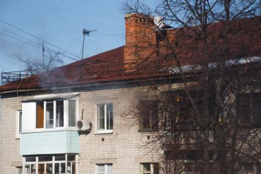 Yanan bir dairenin penceresinden duman çıkıyor.