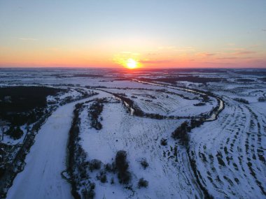 Orman ve donmuş nehir baharda, güneşin batışında erimiş yamalar gibi görünen, Rusya 'da hala kar varken.