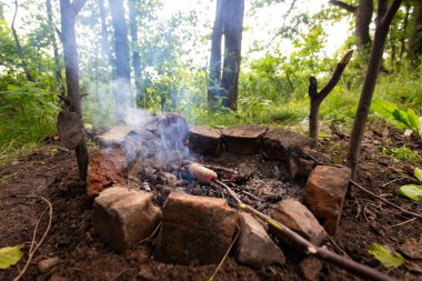 Ateşteki kömürde kızartılmış sosis, kazığa geçirilmiş. Atıştırmalık yiyecek.