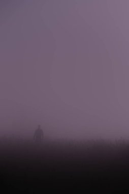 Gece sisli bir adamın silueti Ay ışığıyla aydınlatılıyor