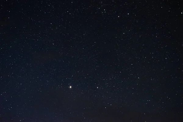 Gece gökyüzündeki yıldızlar bulutlar arasında