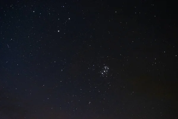 Gece gökyüzündeki yıldızlar bulutlar arasında