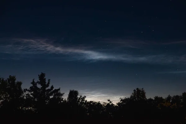 森林の上に夏の夜の潜在的な雲のクローズアップ 夜空に雲が舞う — ストック写真