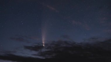 Büyük bir C / 2020 F3 (NEOWISE) kuyrukluyıldızının gece yıldızlı gökyüzündeki bulutlar arasındaki hareketinin zamanlaması