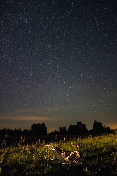 夏夜在田野里的椅子上观察流星雨 — 图库照片