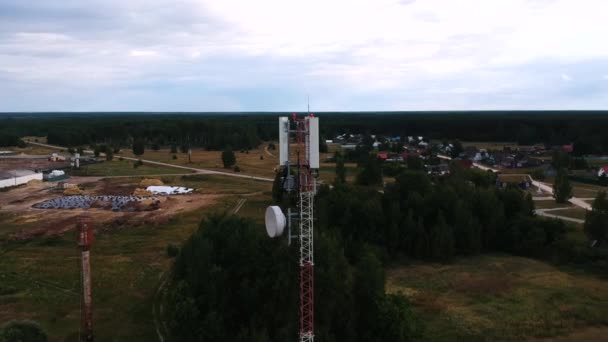 AERIAL: círculo alrededor de una torre de la célula situada en un pueblo ruso, casa de madera. — Vídeos de Stock