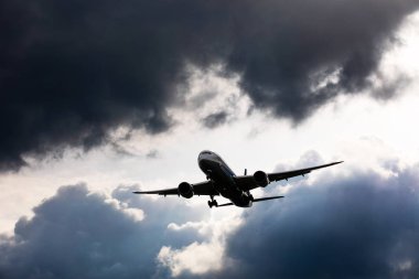 Ağır uçaklar güneşli bir günde yağmur bulutlarının önünde uçar.
