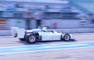 Pit Lane 'den geçen klasik beyaz formüllü araba.