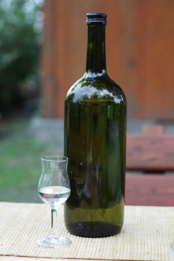 Schnapps şişesi ve masada schnapps bardağı.