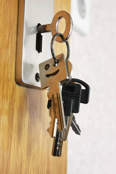 bunch of keys hanging on key in keyhole