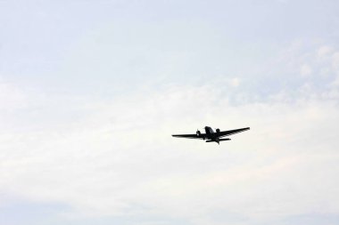 Gri gökyüzünün altında uçan klasik pervane uçağı