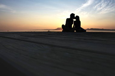 Gün batımında öpüşen çift siluetinin yakın görüntüsü