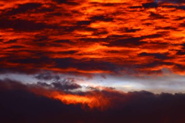 Akşamları dramatik kırmızı gökyüzü ve kara bulutlarla manzara