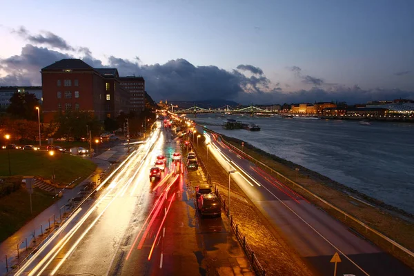Moving cars in evening city with riverside