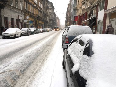 Kış aylarında karla kaplı park edilmiş arabalar.