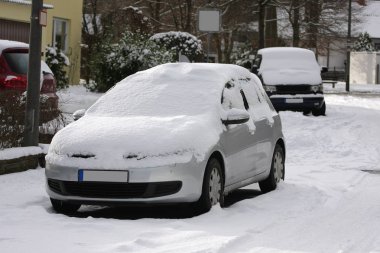 Kış aylarında karla kaplı park edilmiş arabalar.