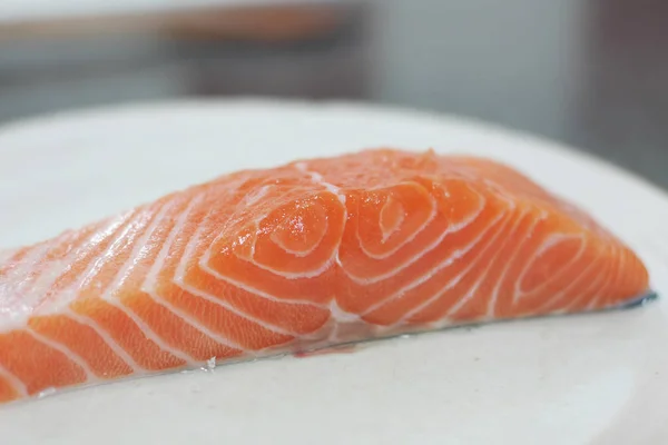 close-up shot of uncooked salmon steak on white plate