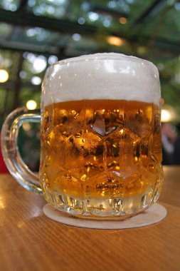 Biranın ahşap masadaki cam kavanozdaki yakın plan görüntüsü.