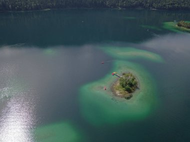 Görkemli manzaralı göl ve tepelerdeki ağaçlar.